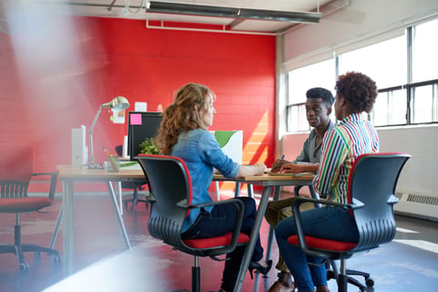 Unposed group of creative business people in an open concept office brainstorming their next project.